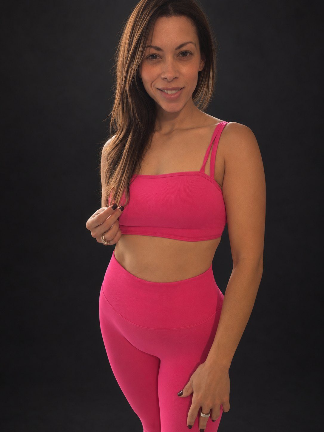 Whitney smiling in pink workout gear